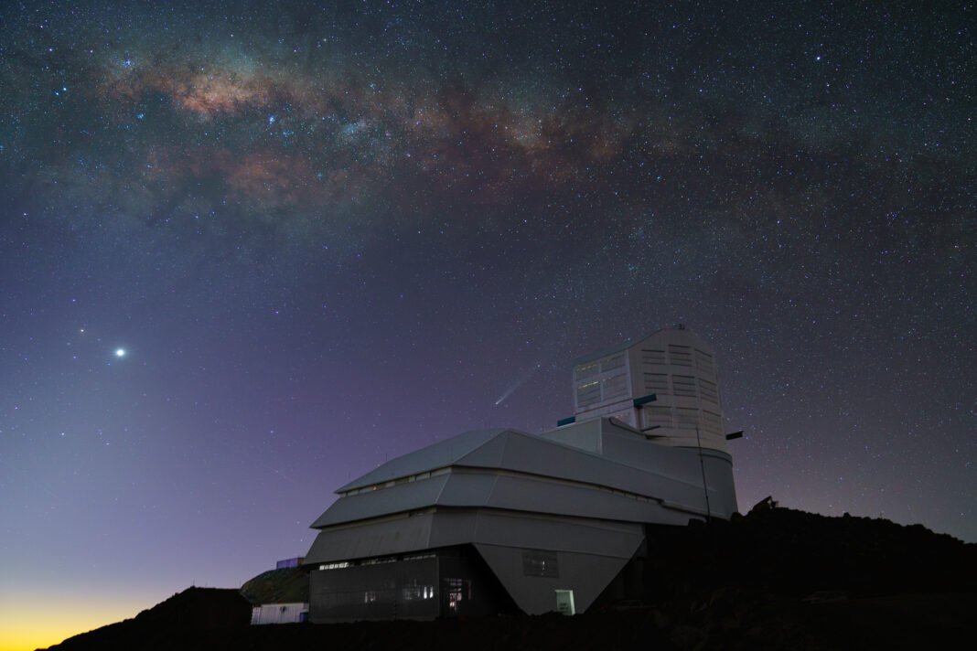 The night sky dazzles over Rubin Observatory in this shot from October 2024. The Milky Way sprawls overhead in the waning light of sunset. Venus shines brightly on the left, while Comet C/2023 A3 (Tsuchinshan–ATLAS) appears just above the observatory at center. Credit: H.Stockebrand/RubinObs/NOIRLab/SLAC/DOE/NSF/AURA